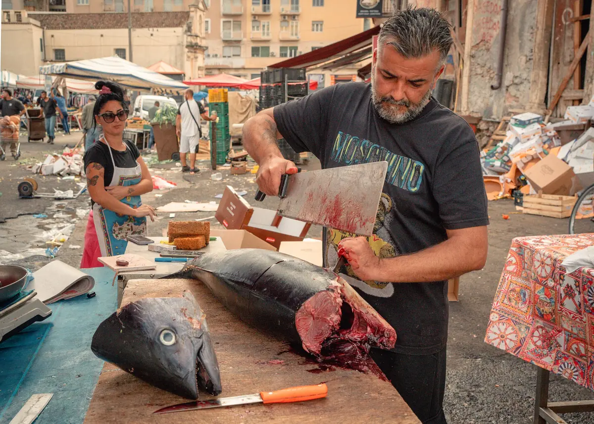 A fishmonger cutting tuna at La Pescheria